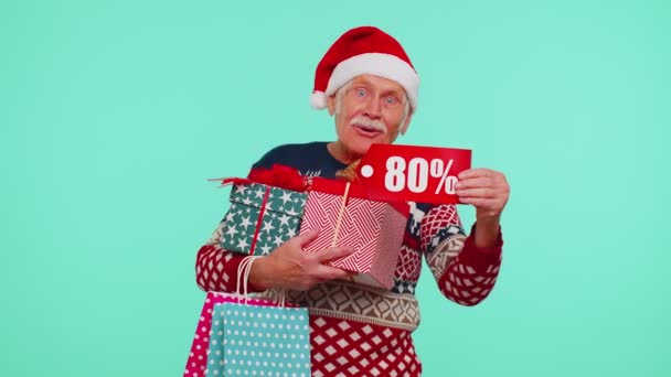 Παππού σε χριστουγεννιάτικο πουλόβερ δείχνει κουτί δώρου και 80 τοις εκατό έκπτωση επιγραφές banner κείμενο — Αρχείο Βίντεο
