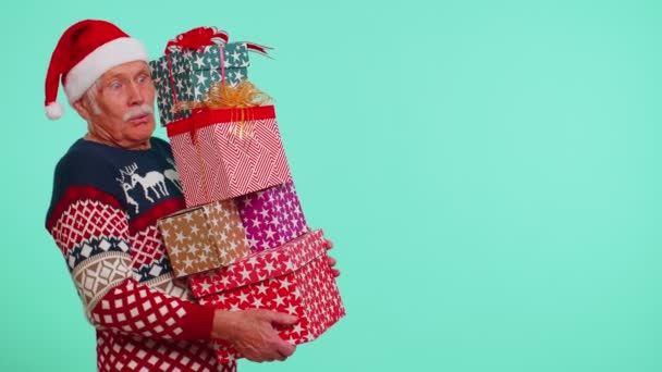 Abuelo mayor hombre en suéter de Navidad celebración de muchas cajas de regalo de Año Nuevo presenta la venta de compras — Vídeos de Stock