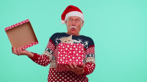 Dědeček ve vánočním svetru s úsměvem, rozbalovací dárek, otvírací box s kočkou, velké překvapení — Stock video