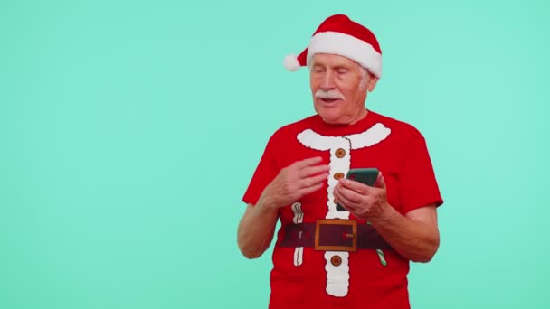 Nonno Santa Natale t-shirt con cellulare che indica il luogo vuoto, area pubblicitaria — Video Stock