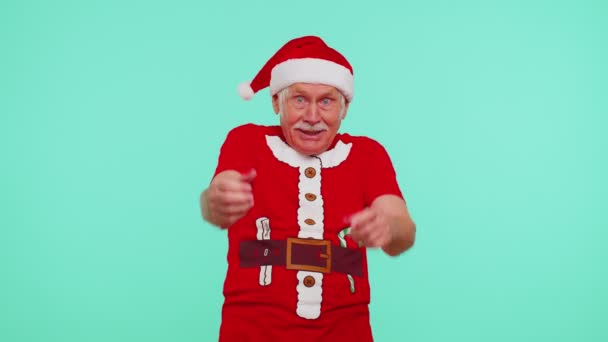 Старший рождественский дедушка улыбается взволнованно, указывая на камеру, красота выбирает счастливого победителя — стоковое видео