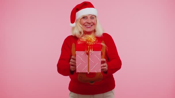 Senior babička v Novém roce svetr a klobouk prezentující vánoční dárkové krabice, nákupní prodej dovolená — Stock video