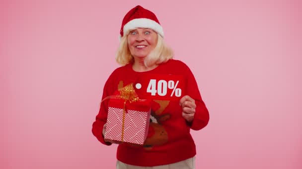 Grandmother in Christmas sweater showing gift box and 40 Percent discount inscriptions banner text — Stock Video