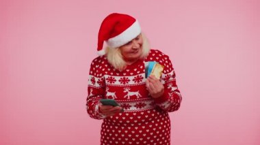 Son sınıf Noel büyükannesi cep telefonu kullanıyor. Plastik banka kartları. Kalebrate.