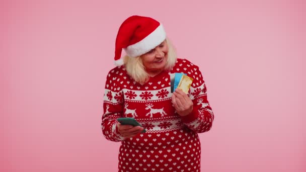 Sênior de Natal avó mulher usar celular plástico cartões bancários de crédito ganhar calebrate wow — Vídeo de Stock