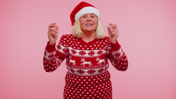 シニアクリスマスのおばあちゃんの女性は、イヤフォンを介して音楽を聞いて、ディスコを踊る、回避 — ストック動画