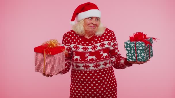 Seniorin im Weihnachtspulli hält zwei Geschenkboxen in der Hand, Weihnachtseinkauf — Stockvideo