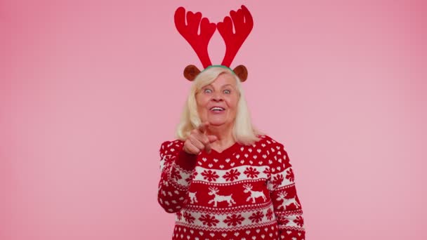 Senior Χριστούγεννα γιαγιά γυναίκα χαμογελά ενθουσιασμένα δείχνοντας την ομορφιά κάμερα επιλέγοντας τυχερός νικητής — Αρχείο Βίντεο