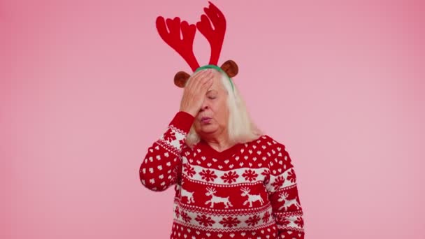 Oppskaket gammel julekvinne som gjør ansiktsuttrykk, kjeder seg, er skuffet, har dårlig resultat – stockvideo