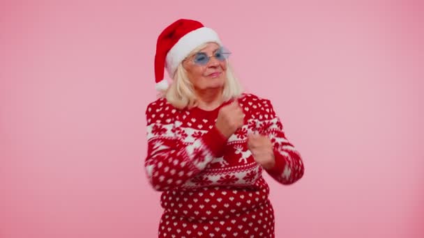 Старшая рождественская бабушка с оленьими рогами слушает музыку, танцует диско, валяет дурака — стоковое видео