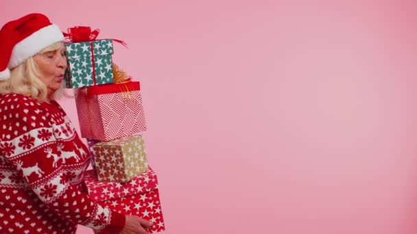 Старшая бабушка женщина в рождественском свитере проведение много подарочных коробок Новогодний подарок покупки — стоковое видео