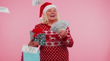 Büyükanne kadın Noel tatiline para harcıyor. Hediye kutuları, alışveriş çantaları.