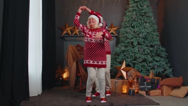 Ouderen familie paar grootmoeder dansen op versierde home room met kerstboom — Stockvideo