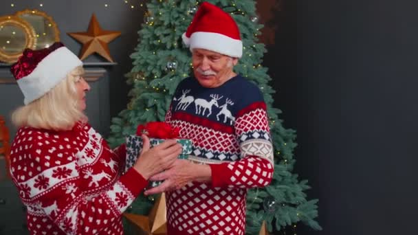 Abuela mayor que presenta la caja de regalo de Navidad al abuelo, casa que celebra el Año Nuevo juntos — Vídeos de Stock