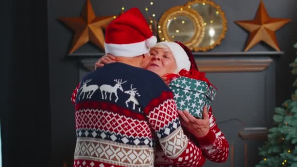 Senioren-Ehepaar Oma überreicht erstaunten Opa Weihnachtsgeschenkschachtel zu Hause — Stockvideo