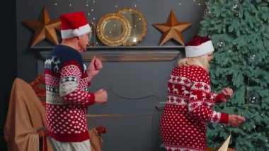 Mutlu son sınıf aile büyükbabaları Noel ağacının yanında dans ediyorlar.