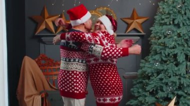 Mutlu yaşlı çift aile babaanne süslemeli Noel odasında kucaklaşıyor.