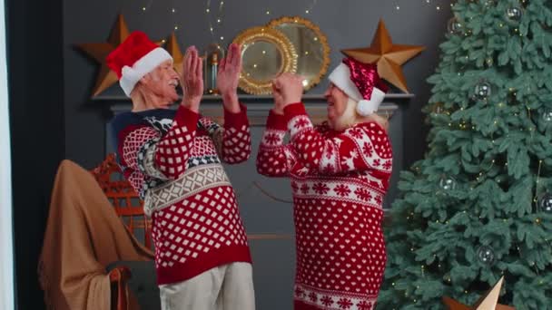 Alegre casado pareja de ancianos abuelos celebrando el éxito ganar grito se regocija en Navidad — Vídeos de Stock