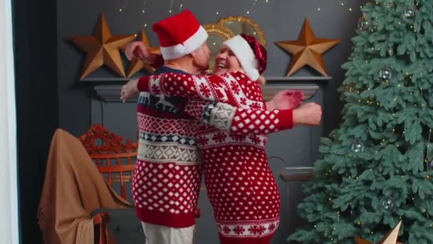 Ευτυχισμένο ηλικιωμένο οικογενειακό ζευγάρι γιαγιά αγκαλιάζει στο διακοσμημένο χριστουγεννιάτικο σπίτι δωμάτιο — Αρχείο Βίντεο
