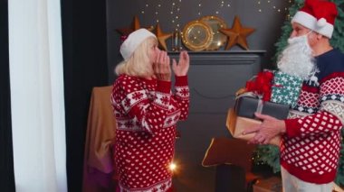 Büyükbaba Noel Baba sürpriz büyük anne ve yaşlı çift ailesine Noel hediyesi veriyor.