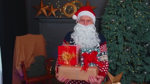 Büyükbaba parodisi Noel Baba hediye kutusunu sunar, evde tatil kutlaması. — Stok video