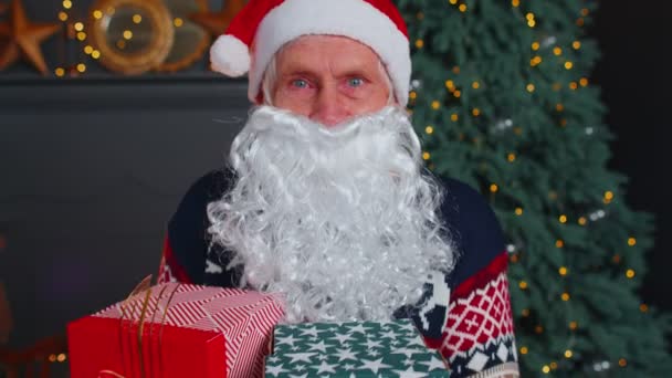 Senior dědeček parodies Santa Claus představuje vánoční dárkové krabice, svátky oslavy doma — Stock video