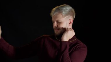 Yakışıklı disko dansçısı ritmik bir şekilde dans ediyor. Gece kulübünün siyah arka planında el ele tutuşuyor.