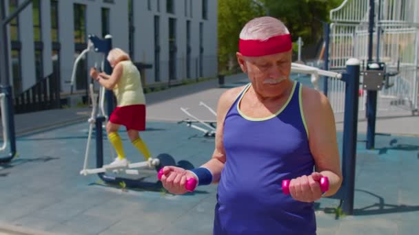 Senior man nagyapa aktív edzés súlyemelés gyakorlása súlyzóval játszótéren — Stock videók