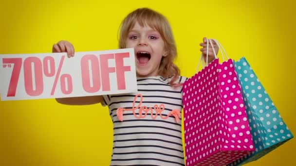 Kindermädchen zeigt Einkaufstüten und bis zu 70 Prozent Rabatt auf Aufschriften, schwarzer Freitag — Stockvideo
