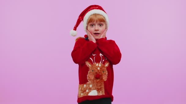 School girl in Christmas sweater raising hands in surprise shocked by sudden victory, wow emotion — Stock Video