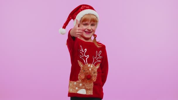 Menina engraçada em camisola de Ano Novo vermelho levanta os polegares concorda com algo bom, como, fundo violeta — Vídeo de Stock