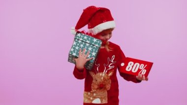 Noel şapkalı küçük kız hediye kutusu ve% 80 indirimli yazılar gösteriyor.