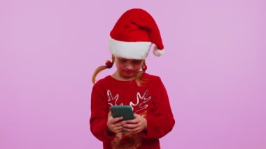 Noel geyiği süveteri giyen mutlu kız akıllı telefon görüntüsü sunuyor. Sevinçle seviniyor. Başarı şansı.