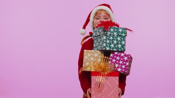 Dívka ve vánočním svetru, Santa klobouk, s úsměvem, drží mnoho dárkových krabic Nový rok dárky — Stock video