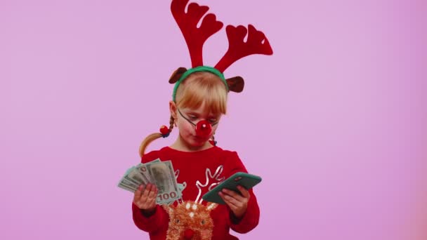 Dívka v červeném vánočním jeleni parohy hledá smartphone radovat vyhrát úspěch štěstí příjem peněz — Stock video