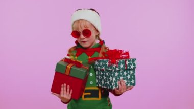 Küçük çocuk Noel Baba Elf 'in elinde iki hediye kutusu var, bayram alışverişi.