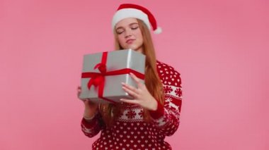 Komik kız Noel hediyesi olarak hediye edilen süveteri giyer, hediye kutusuyla ilgilenir.