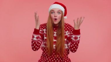 Noel şapkalı ergen bir kız aniden kazanılan zafer karşısında şaşkınlıkla el kaldırıyor.