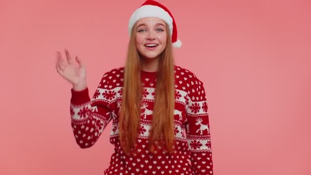 Vrouw in kerst trui golven hand palm in hallo gebaar verwelkomt iemand om Nieuwjaar te vieren — Stockvideo