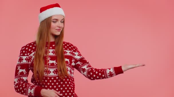 Mulher usa veado vermelho ano novo suéter mostrando polegares para cima e apontando para no espaço de publicidade em branco — Vídeo de Stock