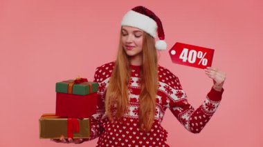 Noel süveteri giyen kadın hediye kutusu ve% 40 indirimli yazı notu gösteriyor.