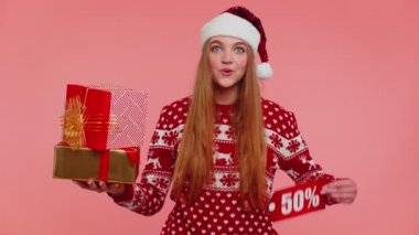 Kırmızı Noel kazaklı kız hediye kutusu ve% 50 indirimli yazılar gösteriyor.