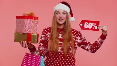 Noel kazaklı kadın hediye kutuları ve% 60 indirimli yazılar gösteriyor.