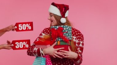 Hediye kutuları tutan ve Noel indirimleri alan bir kız. Yazılar, alışveriş satışı.