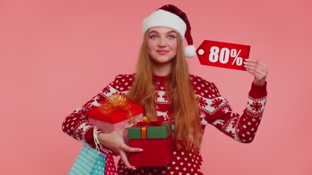 Mujer en jersey de Navidad mostrando caja de regalo y 80 por ciento de descuento inscripciones banner texto nota — Vídeo de stock