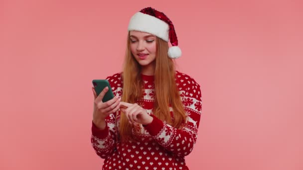 Žena ve vánočním svetru vypadá smartphone displej upřímně radovat vyhrát úspěch štěstí, palec nahoru — Stock video