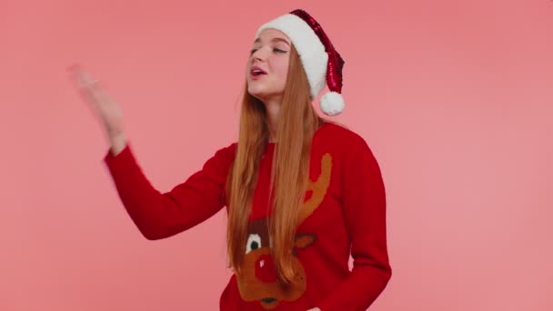 Mädchen im Weihnachtspulli schickt viele Luftküsse in die Kamera und lächelt, vermisst dich, liebe — Stockvideo