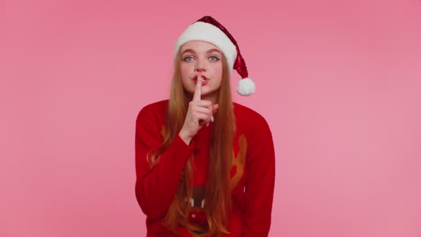 Kobieta nosi czerwony świąteczny sweter naciska palcem wskazującym usta sprawia, że gest milczenia znak, sekret — Wideo stockowe