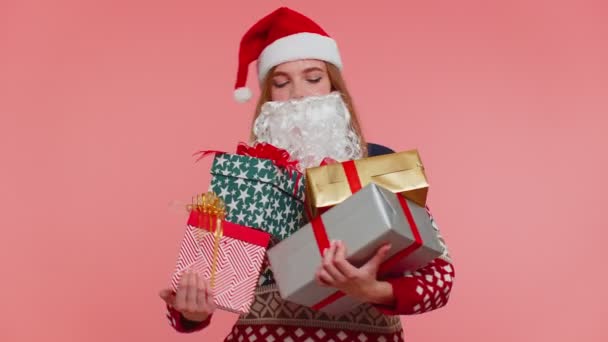 Dziewczyna w Boże Narodzenie sztuczna broda Świętego Mikołaja zaskoczony z pudełek prezentowych podekscytowany wielu prezentów wakacyjnych — Wideo stockowe
