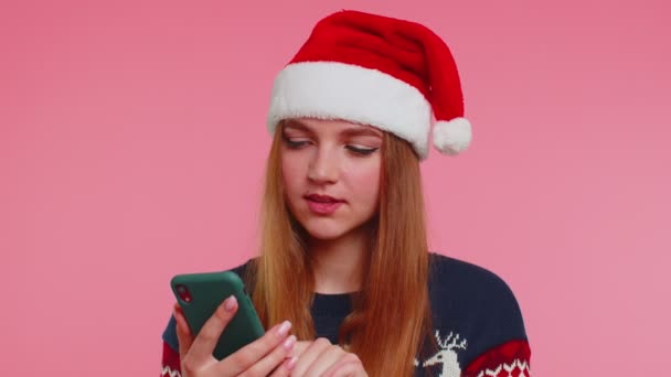 Kvinna i snygg jul tröja ser smartphone display uppriktigt glädjande vinna framgång lycka — Stockvideo